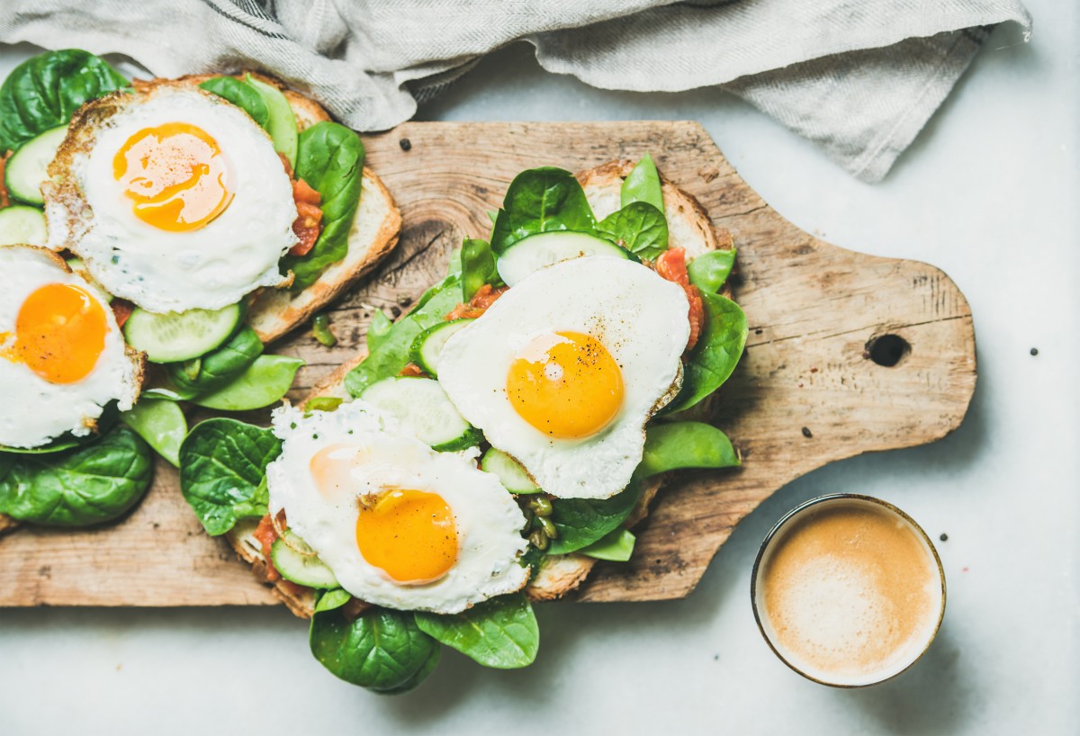 Frühstückstoast mit sonnigen Eiern und vielen Grüns