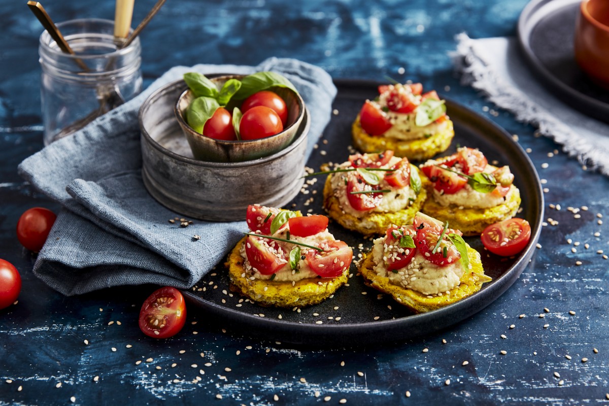 Omelettes (canapes) with hummus, cherry tomatoes and sesame