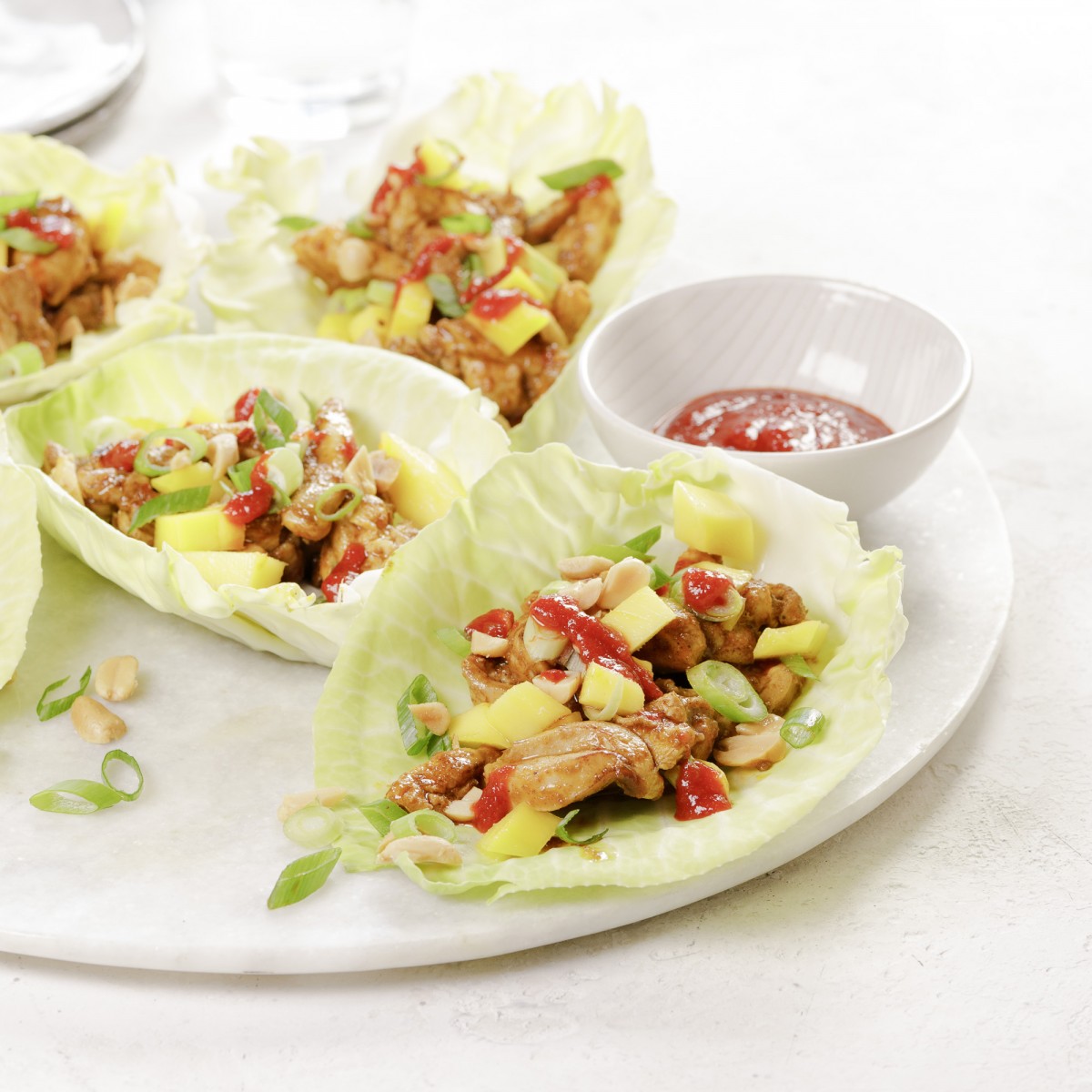 Open spitskoolwraps met spicy kip, mango en lente-uitjes