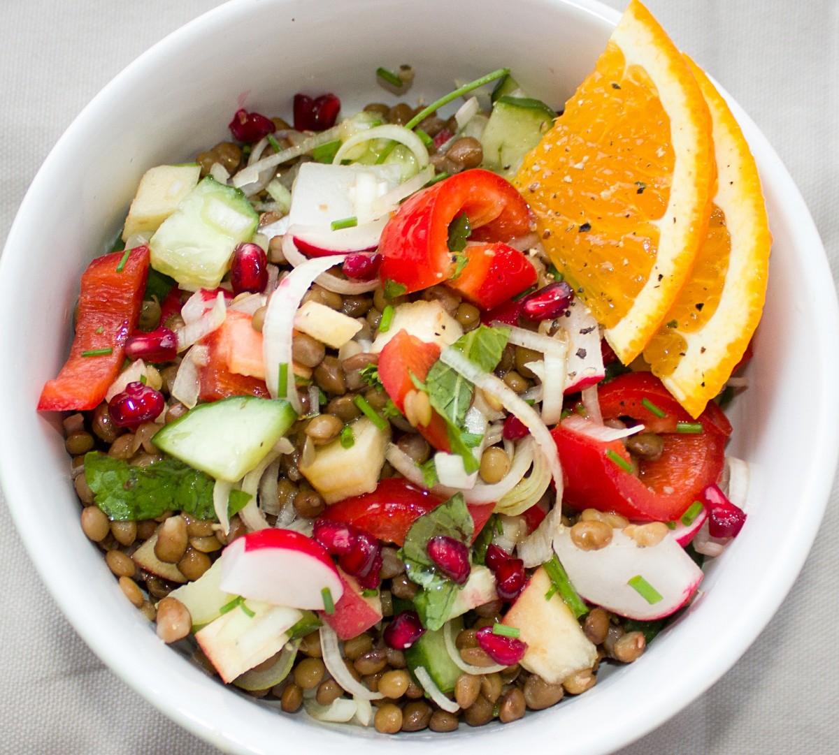 Linzensalade met appel, radijs, paprika, granaatappelpitjes en sinaasappeldressing