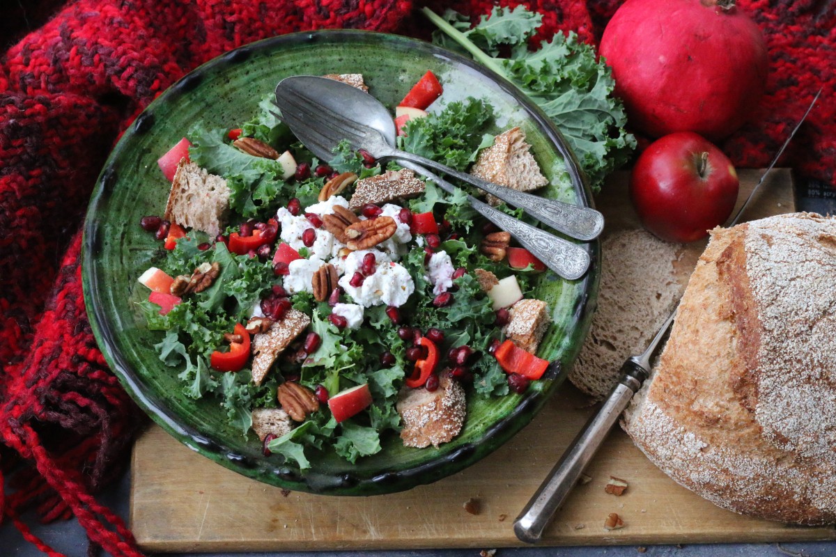 Wintersalade van boerenkool met appel, paprika, pecannoten, geitenkaas, granaatappelpitjes en een warme dressing