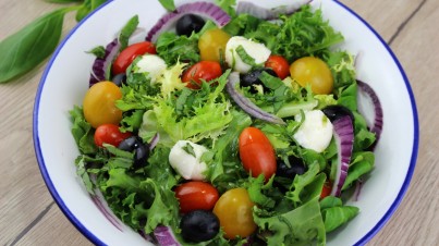 Mediterranean salad with cherry tomatoes, black olives, mozzarella and basil