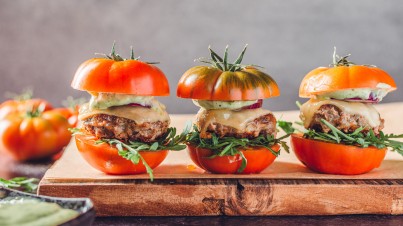 Italiaanse hamburgers met basilicummayonaise op een broodje van tomaat 
