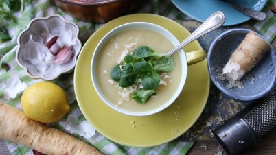 Pastinaaksoep met kokosmelk, citroen, geraspte mierikswortel en een topping van veldsla