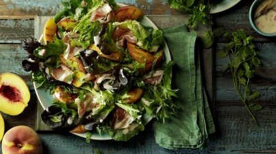 Salade met gegrilde perzik, prosciutto en yoghurt dressing