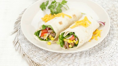 Burritos de tortilla con lechuga, tiras de ternera, aguacate, tomates y queso Cheddar