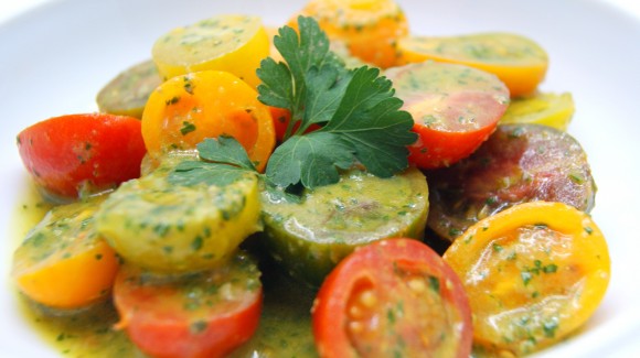 Ensalada de tomates cherry variados con salsa de perejil, albahaca y anchoas