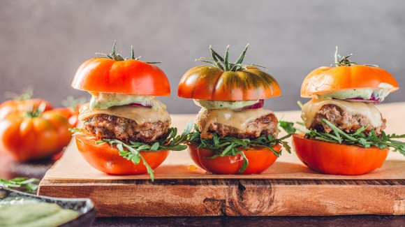 Italiaanse hamburgers met basilicummayonaise op een broodje van tomaat 