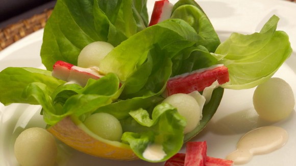 Екзотичний салат з листям салату, з динею і крабовими паличками