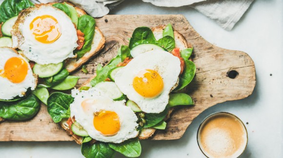 Toast de petit-déjeuner avec des œufs au plat et légumes verts