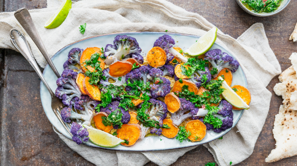 Traybake van bloemkool, zoete aardappel en groenekruidenolie Traybake van bloemkool, zoete aardappel en groenekruidenolie